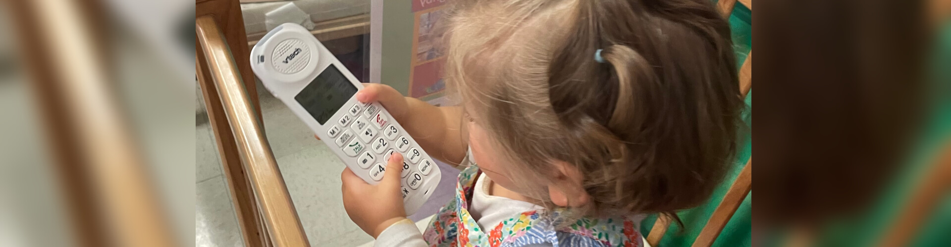 toddler holding a telephone