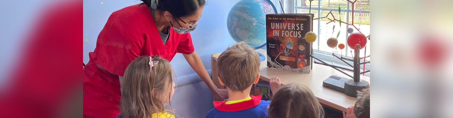 teacher and students studying planets